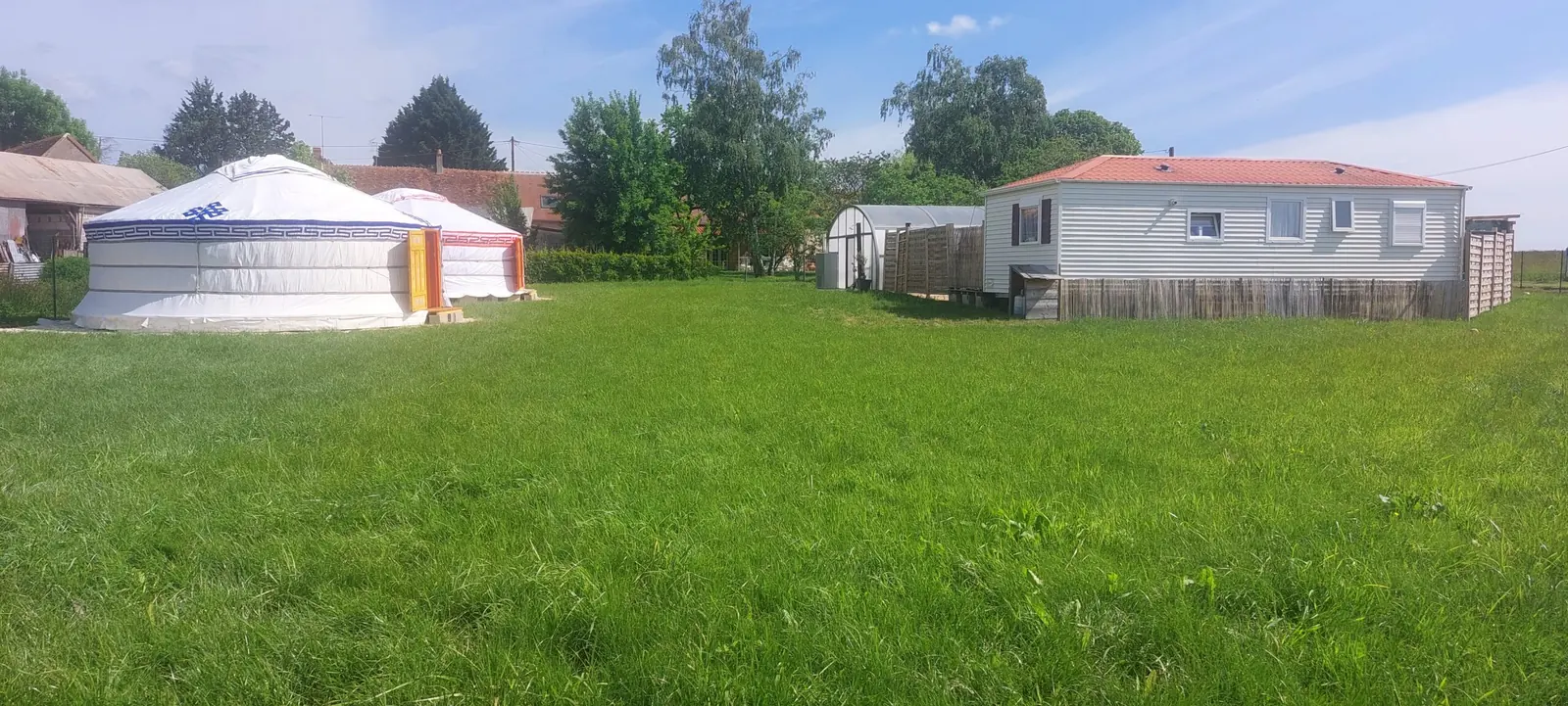 Le terrain du gîte avec la yourte à gauche et le mobil-home à droite