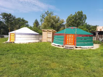 Les deux yourtes du gîte sur la pelouse, l'une blanche et l'autre verte